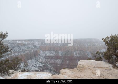 Look out over Grand Canyon rock formations in winter as snow cloud desecends Stock Photo