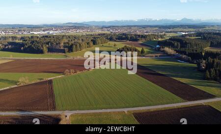 Aerial view with drone of different colored fields, road and alps in spring in Bavaria Stock Photo