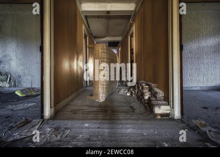 An old damaged bed in an abandoned ruined building Stock Photo
