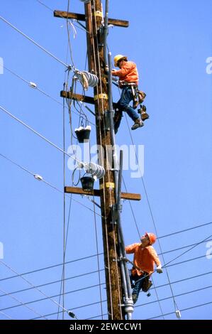 Men in hardhats working on electrical lines. Stock Photo