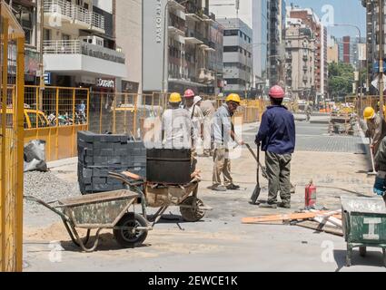 Workers resurface road along Corrientes Avenue, Buenos Aires, Argentina Stock Photo
