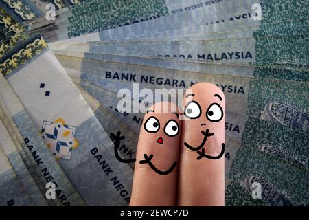 Two fingers are decorated as two person. One of them is worrying about the economy. Stock Photo