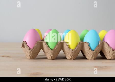 Colorful Easter eggs in egg carton on the table with copy space for text. Stock Photo