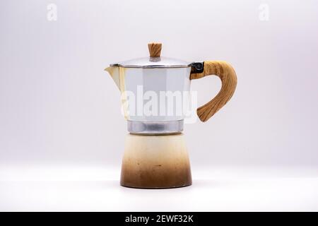 Old used white moka pot with wood finish handle on white background. Stock Photo
