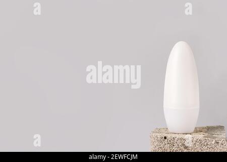 White bottle with Body antiperspirant deodorant roll-on staying on the stone on grey background. template, copy space Stock Photo