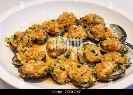 A delicious Chinese Cantonese dish, steamed fresh abalone with garlic Stock Photo