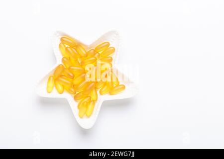 Omega 3 capsules in star shape plate on white background Fish oil Yellow  softgels Vitamin D, E, A supplement Concept of healthcare Top view, flat  lay Stock Photo - Alamy