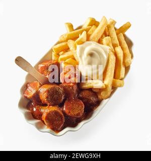 Top view of appetizing French fries with mayo served with grilled sausages in sauce in plate on white background Stock Photo
