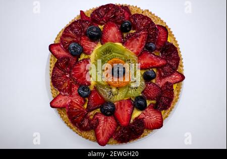 Fresh fruit tart with strawberries, kiwi and orange, isolated on white background top view Stock Photo