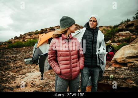Caucasian friends smiling together camping on mountain peak Stock Photo