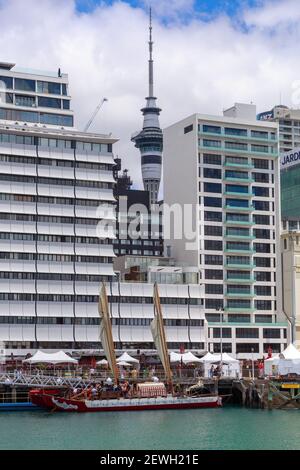 A traditional Maori waka moana, or large ocean-going canoe, in front of the skyline of Auckland, New Zealand during the Tamaki Herenga Waka Festival Stock Photo