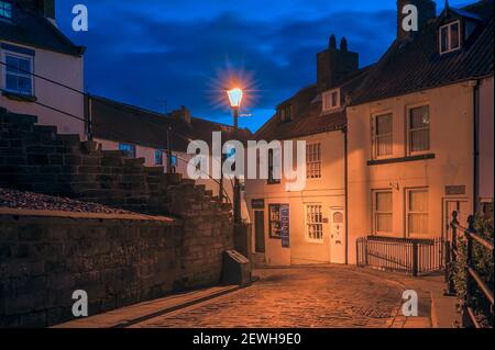 WHITBY, NORTH YORKSHIRE, UK - MARCH 15, 2010:  Old vintage street lamp at night on a cobbled street in the town Stock Photo