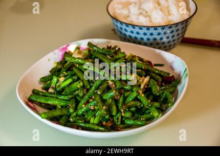The Sichuan classic dish of dry fried snake beans cooked using Omipork a plant-based meat substitute in its ‘minced pork’ form. Stock Photo