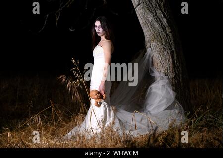 Horror Scene of a Woman Possessed holding a doll. High quality photo.