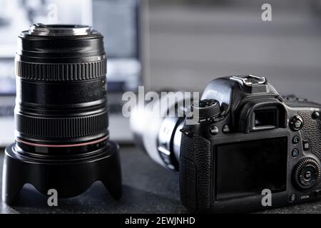 Professional camera and lens close-up on a blurred background. Stock Photo