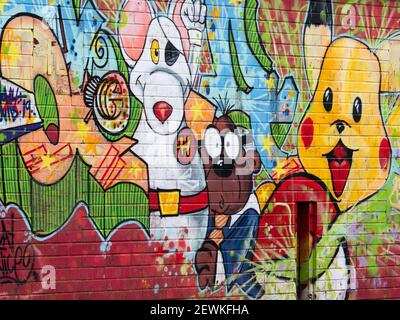 Graffiti covered brick wall in childrens' playground in Greenspace Park, Westbury, Wiltshire, England, UK. Stock Photo