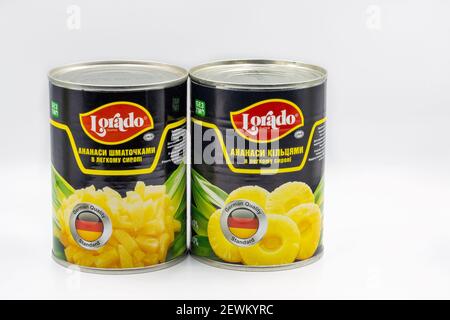 KYIV, UKRAINE - DECEMBER 24, 2020: Studio shoot of tins with Lorado pineapple slices and rings in light syrup closeup against white background. Stock Photo