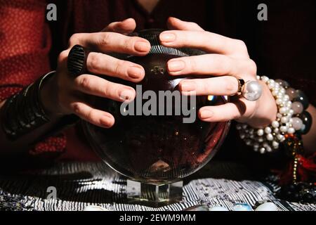 Closeup of fortuneteller's hands on a glass orb. Prediction of the future. Mystic interior Stock Photo