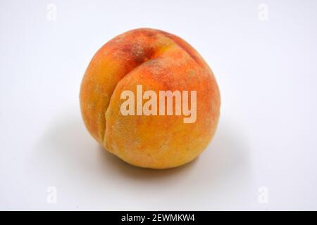 Tasty and useful fresh fruits, ripe red and orange peaches with a terry white skurt are located on a white background. Stock Photo