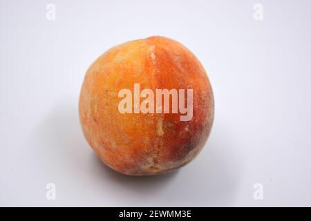 Tasty and useful fresh fruits, ripe red and orange peaches with a terry white skurt are located on a white background. Stock Photo