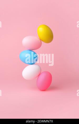 colorful easter eggs balancing over pink background Stock Photo