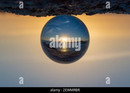 Sunset at the ocean seen through a crystal ball Stock Photo