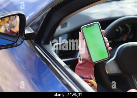 hand showing green screen smart phone in the car Stock Photo