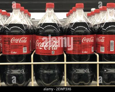 OCEAN SPRINGS, UNITED STATES - Mar 02, 2021: CocaCola bottles lined up on store shelf. Stock Photo