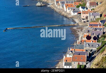 CROVIE VILLAGE ABERDEENSHIRE SCOTLAND THE ROW OF HOUSES JETTY WALL AND BLUE SEA  OF THE BAY Stock Photo