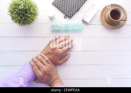 man's hand on table suffering wrist pain top down  Stock Photo