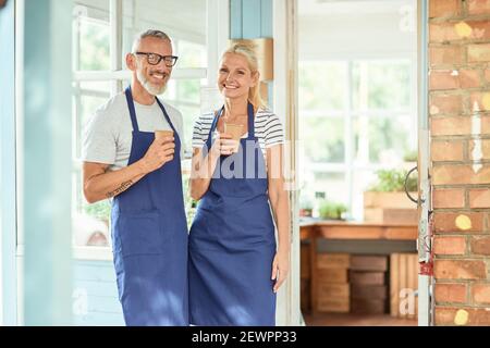 Middle aged caucasian couple drinking coffee during working day rest Stock Photo