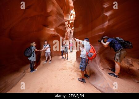 Tourists explore a slot canyon in Upper Antelope Canyon, Navajo Land, Arizona, United States of America, North America Stock Photo