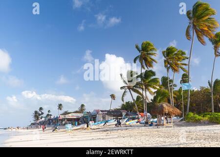 Punta Cana, Dominican republic - January 15, 2020: Tourists and staff are on a sandy beach of Punta Cana resort near small souvenir shops and beach re Stock Photo