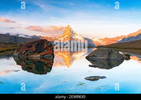 Matterhorn lit by sunrise reflected in the calm water of lake Stellisee, Zermatt, Valais Canton, Switzerland, Europe