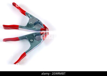 The metal spring clamps with red plastic handles and tip isolated on white background Stock Photo