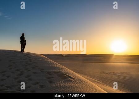 Tuareg standing on a sand dune in the Tenere Desert at sunrise, Sahara, Niger, Africa Stock Photo