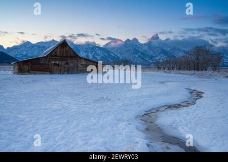 First light on Teton Range at Moulton Barn in the snow, Grand Teton National Park, Wyoming, United States of America, North America Stock Photo