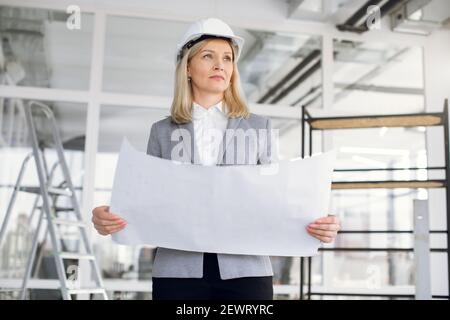 Qualified female designer checking building project Stock Photo