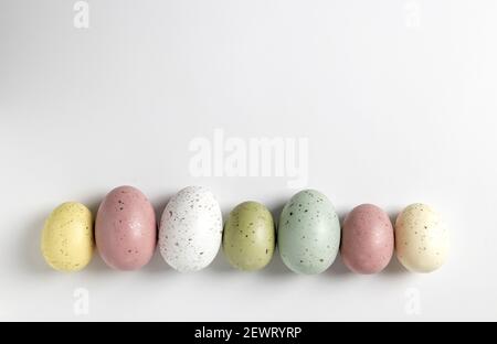 Speckled pastel easter eggs in a horizontal line on white background Stock Photo
