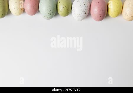 Speckled pastel easter eggs in a horizontal line on white background Stock Photo