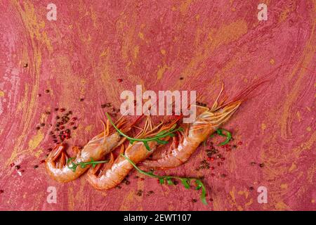 Juicy fresh shrimp seamless pattern isolated on red background. Place for your text. Shrimp seamless pattern on a red background. Seafood shrimp backg Stock Photo
