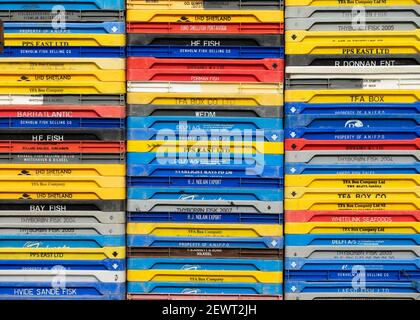 Coloured fishing containers stacked in Cruden Bay harbour, Aberdeenshire, Scotland, UK Stock Photo