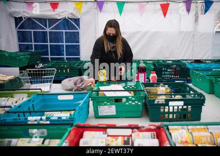 A volunteer sorts food at the Ringcross Foodbank, in north London, where vension from wild deer, which normally would have gone to some of the finest restaurants in the country, is distributed. The deer population has risen to over 2 million during lockdown, the highest level in over 1,000 years, largely as a result of restaurant closures. Picture date: Wednesday March 3, 2021. Stock Photo