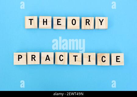 Concept of theory and practice relationship or connection. Wooden blocks with the words theory and practice on yellow background.
