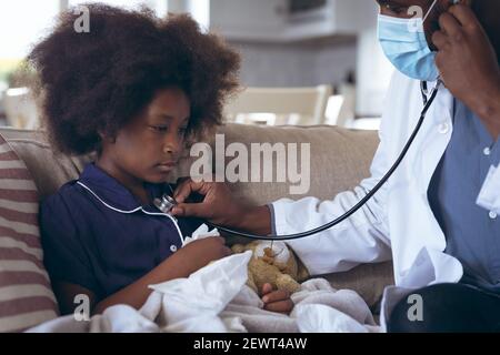 African american male doctor using a stethoscope on child patient Stock Photo
