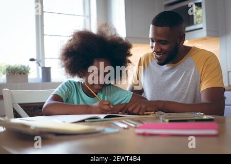 African american girl doing homework with her father Stock Photo