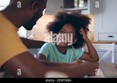 African american girl doing homework with her father Stock Photo
