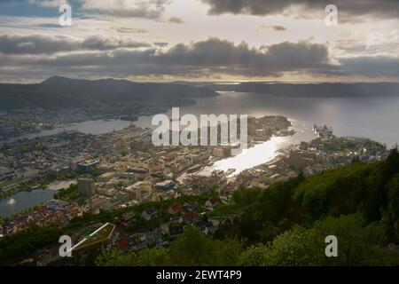 Beautiful scene bright rays of sun shining through the cloud layers onto the city of Bergen in Norway. Stock Photo