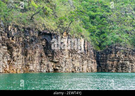 Rock walls of on the shore of the Lake of Furnas, Capitólio MG, Brazil. Green water of the lake, sedimentary rocks and the vegetation growing up the r Stock Photo