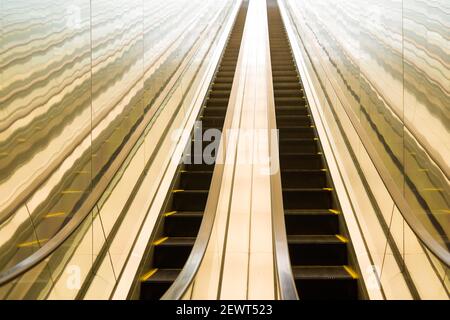 Long escalator with bright light at te end. Stock Photo